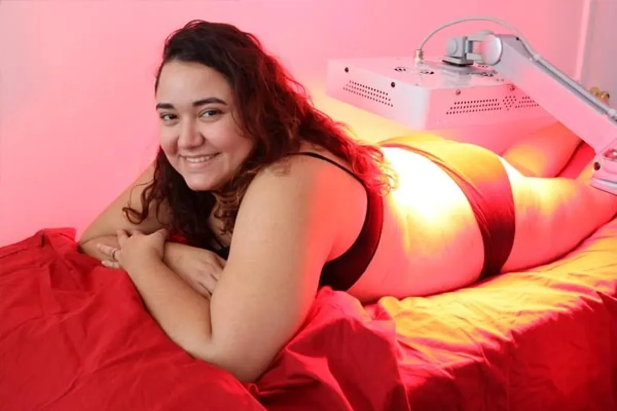 A red light therapy panel positioned over a patient on a treatment table.