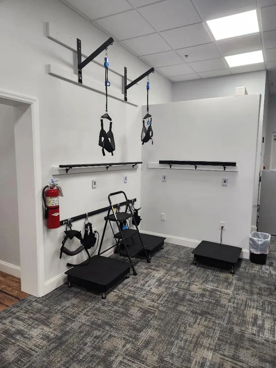 The rehabilitation room, with its wall-mounted harness rig and step platforms.